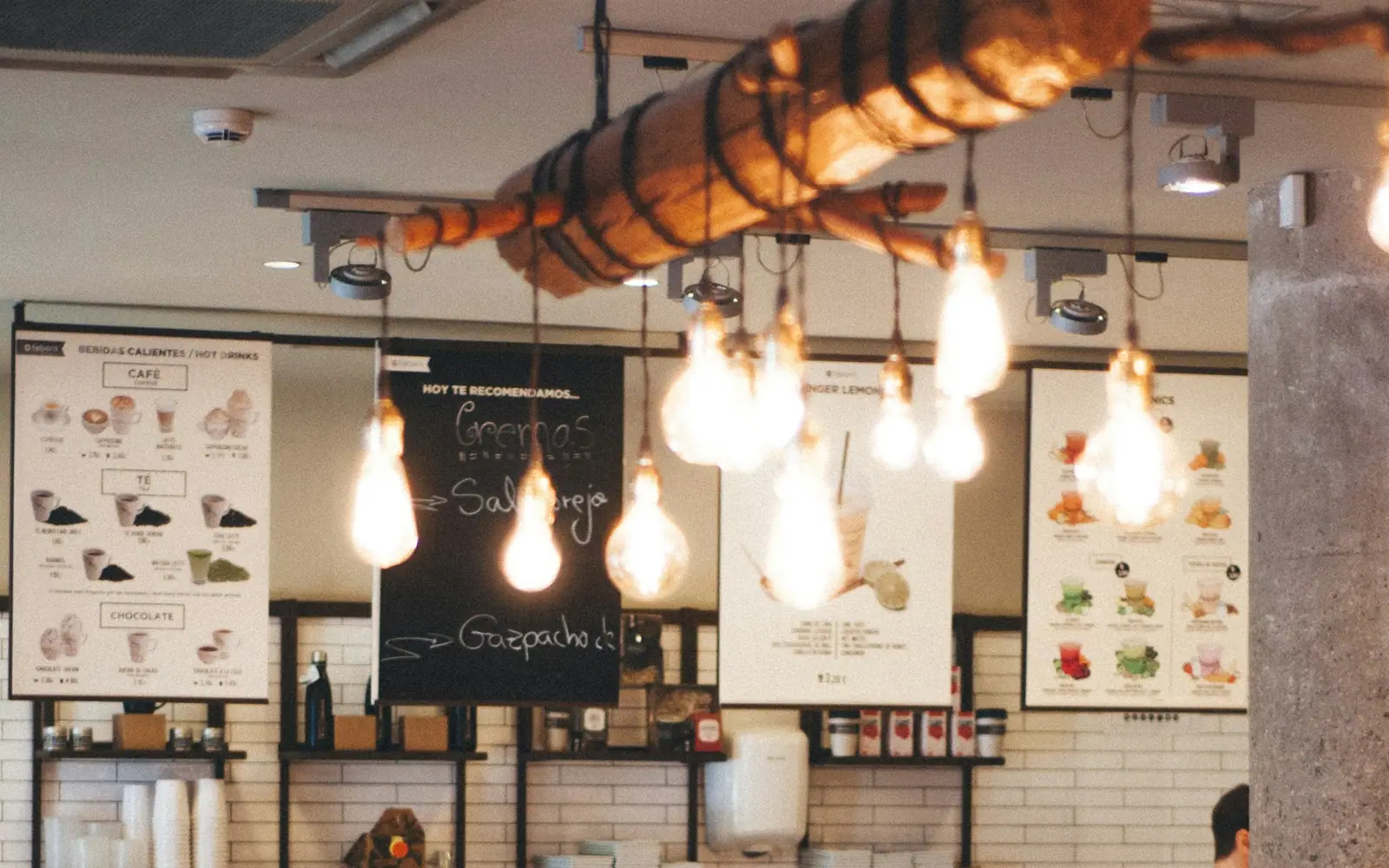 Cafe interior with bare light bulbs hanging in front of menu boards